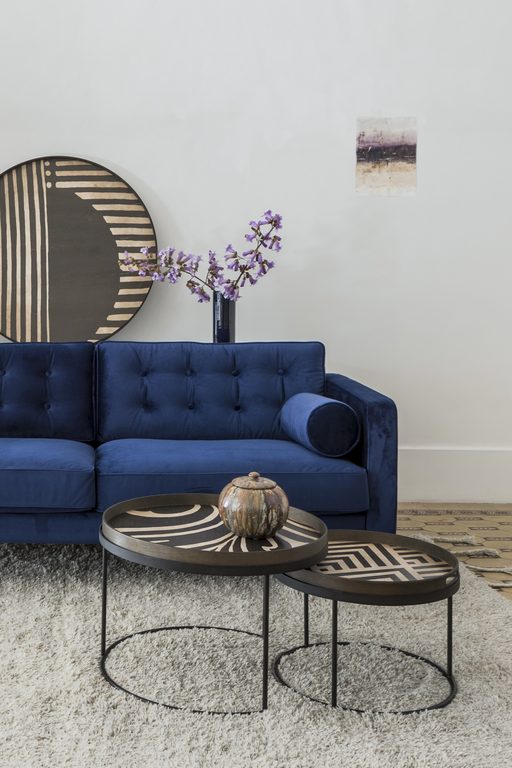 Blaues Sofa und runde Tische